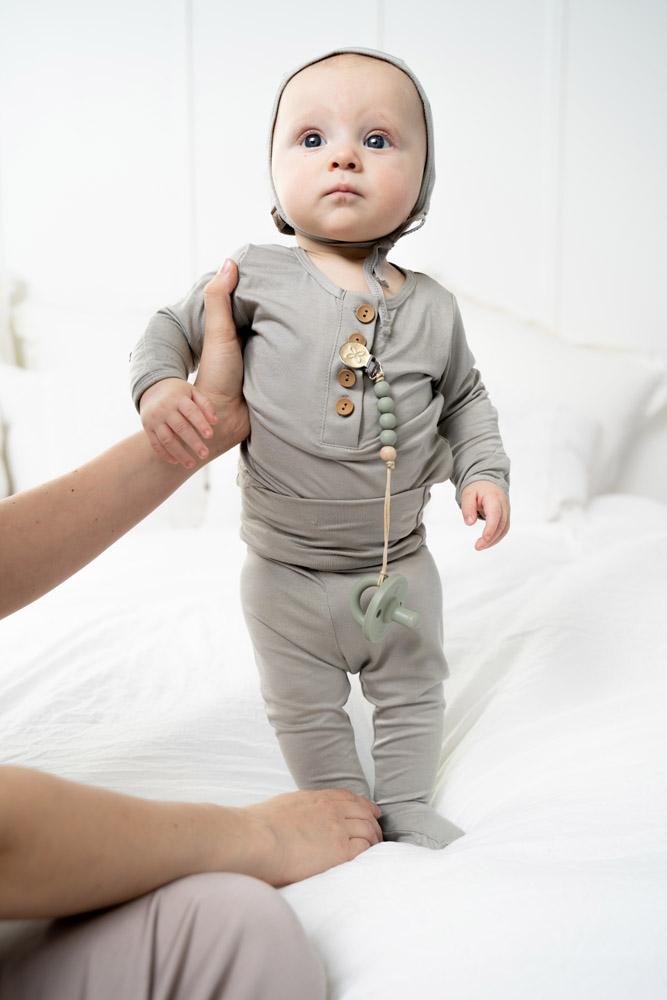 A cute baby outfit set featuring a soft fabric blend with functional wooden buttons, designed for comfort and style for infants.