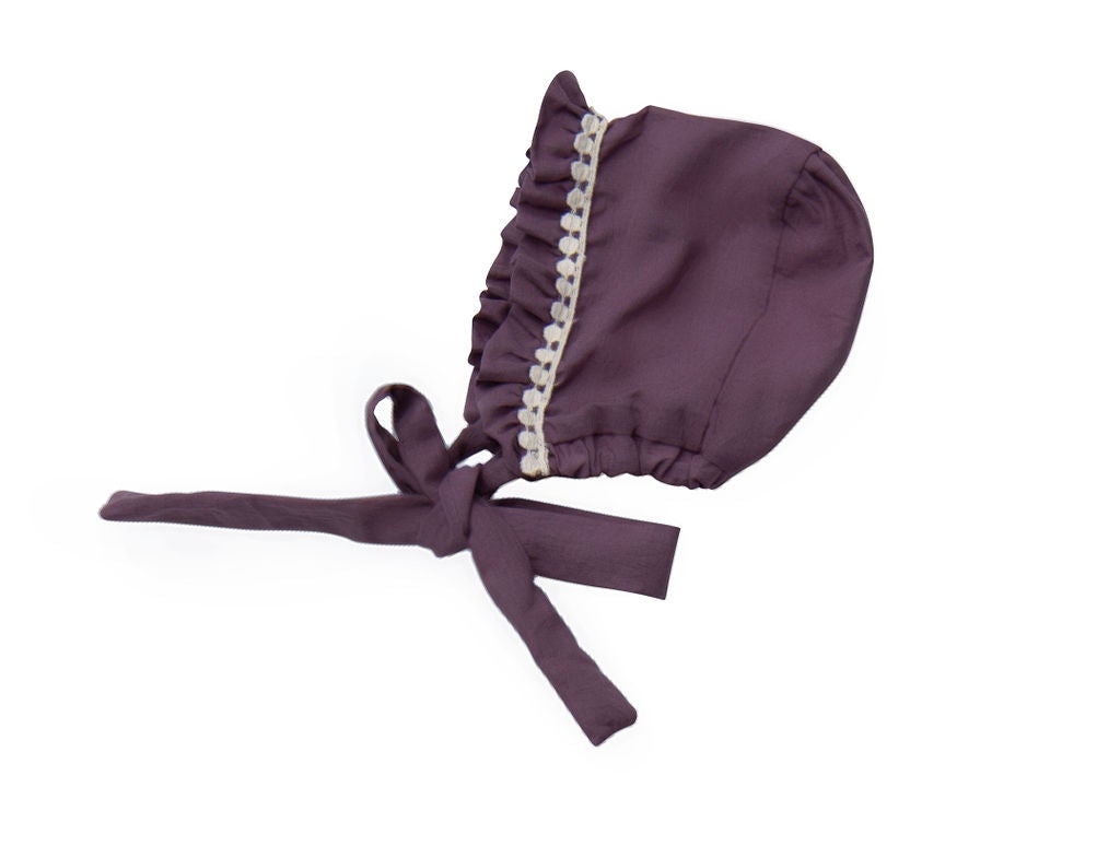 A beautifully crafted Violet Field Bonnet featuring intricate crocheted lace and rich purple fabric, perfect for elegant occasions.