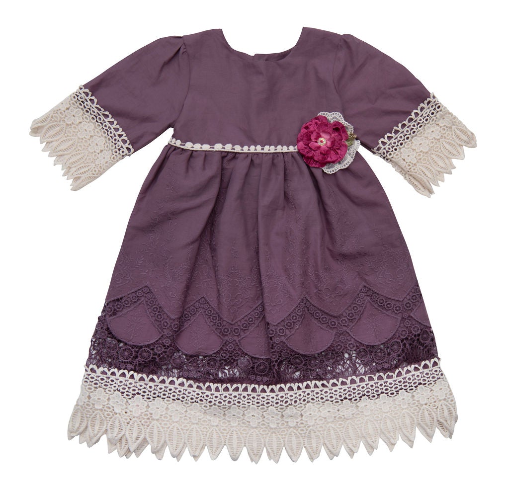 A beautiful Violet Field Dress featuring intricate crocheted lace and rich purple fabric, perfect for elegant occasions.