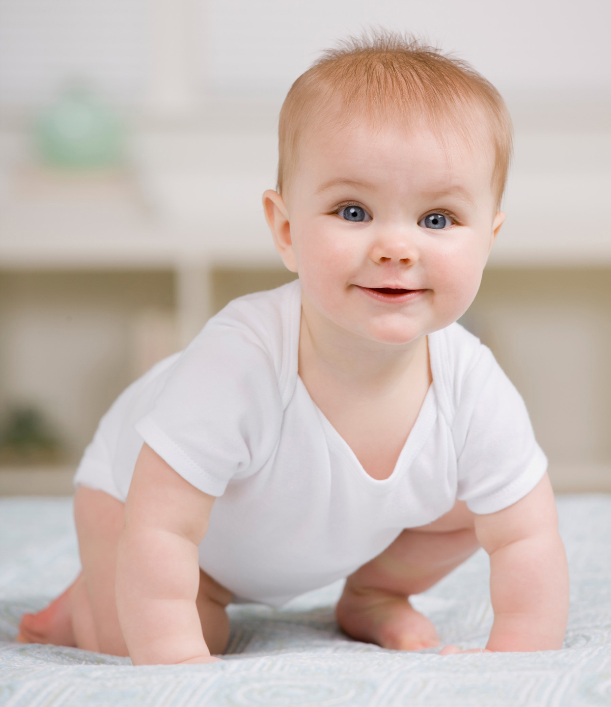 Smiling baby in white onesie.