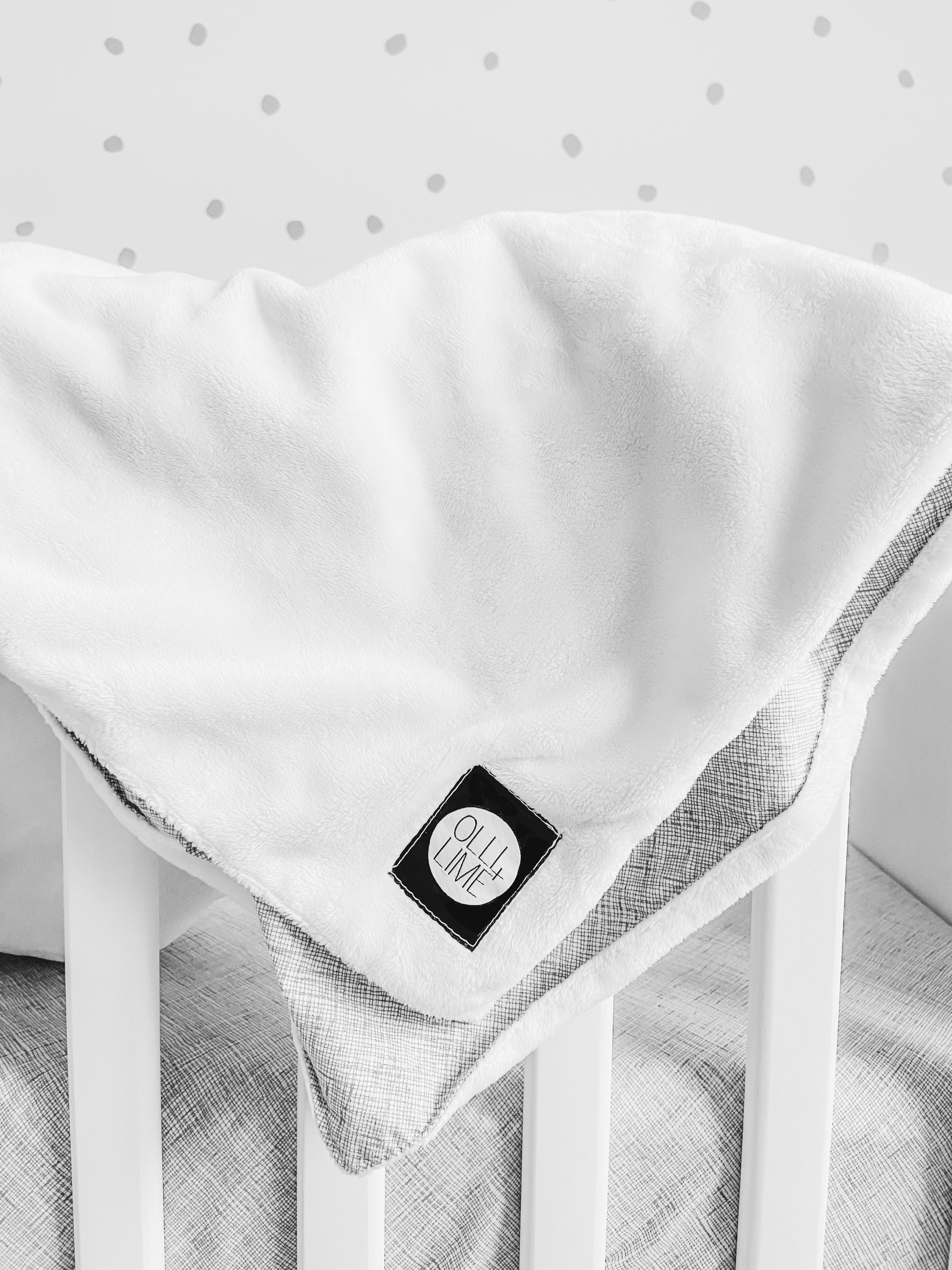 Avi Baby Blanket featuring modern design with neutral tones and playful lines, made from 100% cotton percale and soft minky fabric.