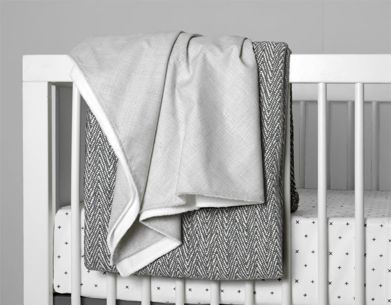 Avi Baby Blanket featuring modern design with neutral tones and playful lines, made from 100% cotton percale and soft minky fabric.