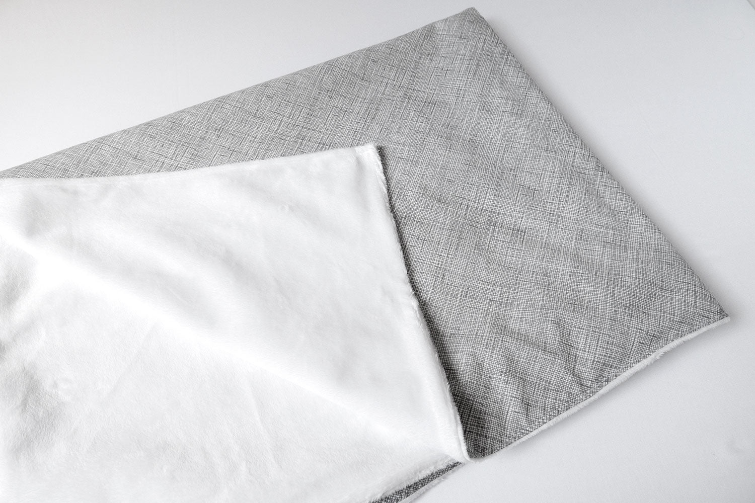 Avi Baby Blanket featuring modern design with neutral tones and playful lines, made from 100% cotton percale and soft minky fabric.