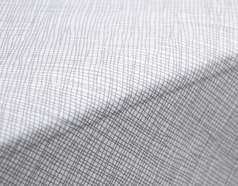 Avi Fitted Crib Sheet featuring modern neutral tones and sporadic lines, designed for a stylish nursery.