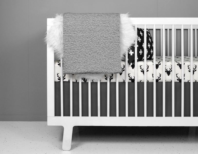 Stylish charcoal gray crib skirt tailored for standard cribs, made from heavyweight cotton twill.