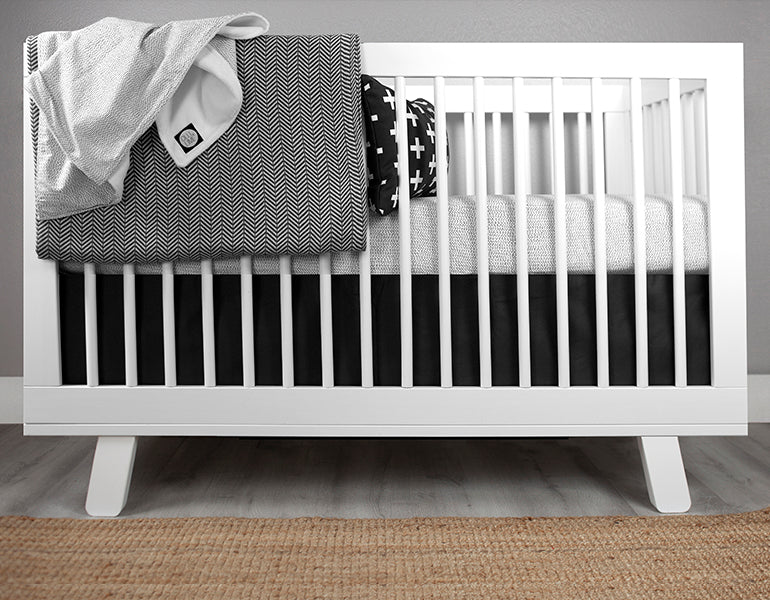 Dashing Deluxe Crib Bedding Set featuring modern Tiny Dash design with organic cotton materials, including a crib sheet, plush blanket, and crib skirt.