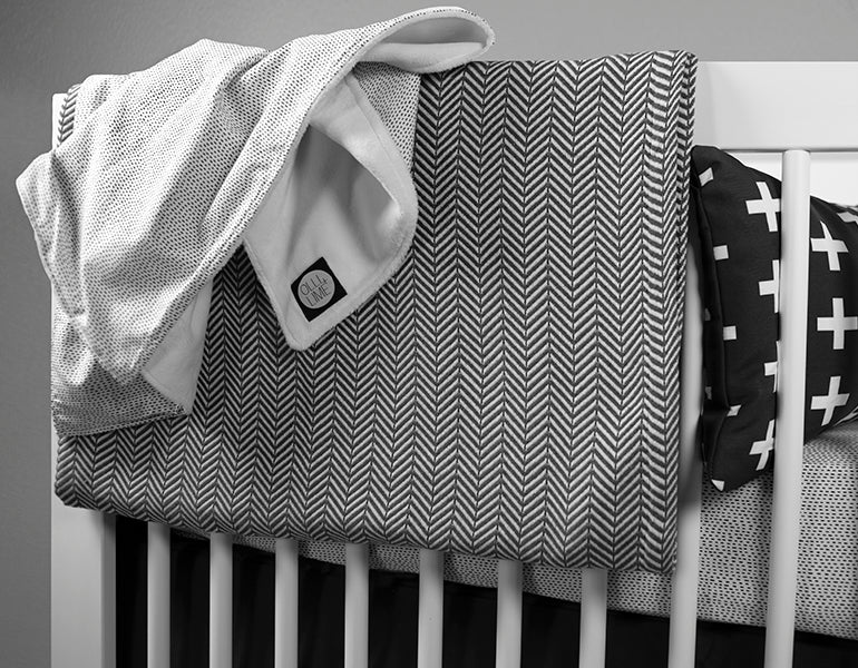 Dashing Deluxe Crib Bedding Set featuring modern Tiny Dash design with organic cotton materials, including a crib sheet, plush blanket, and crib skirt.