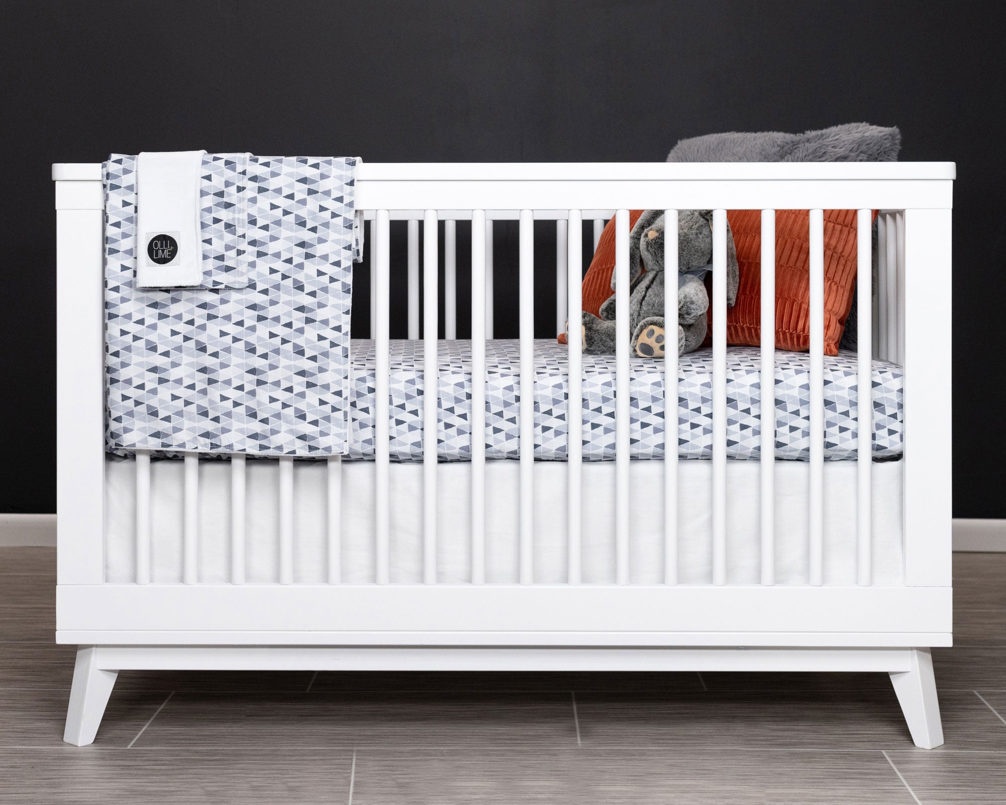 Gray Banners Marching Deluxe Crib Bedding Set featuring modern gray triangle patterns and soft cotton materials.