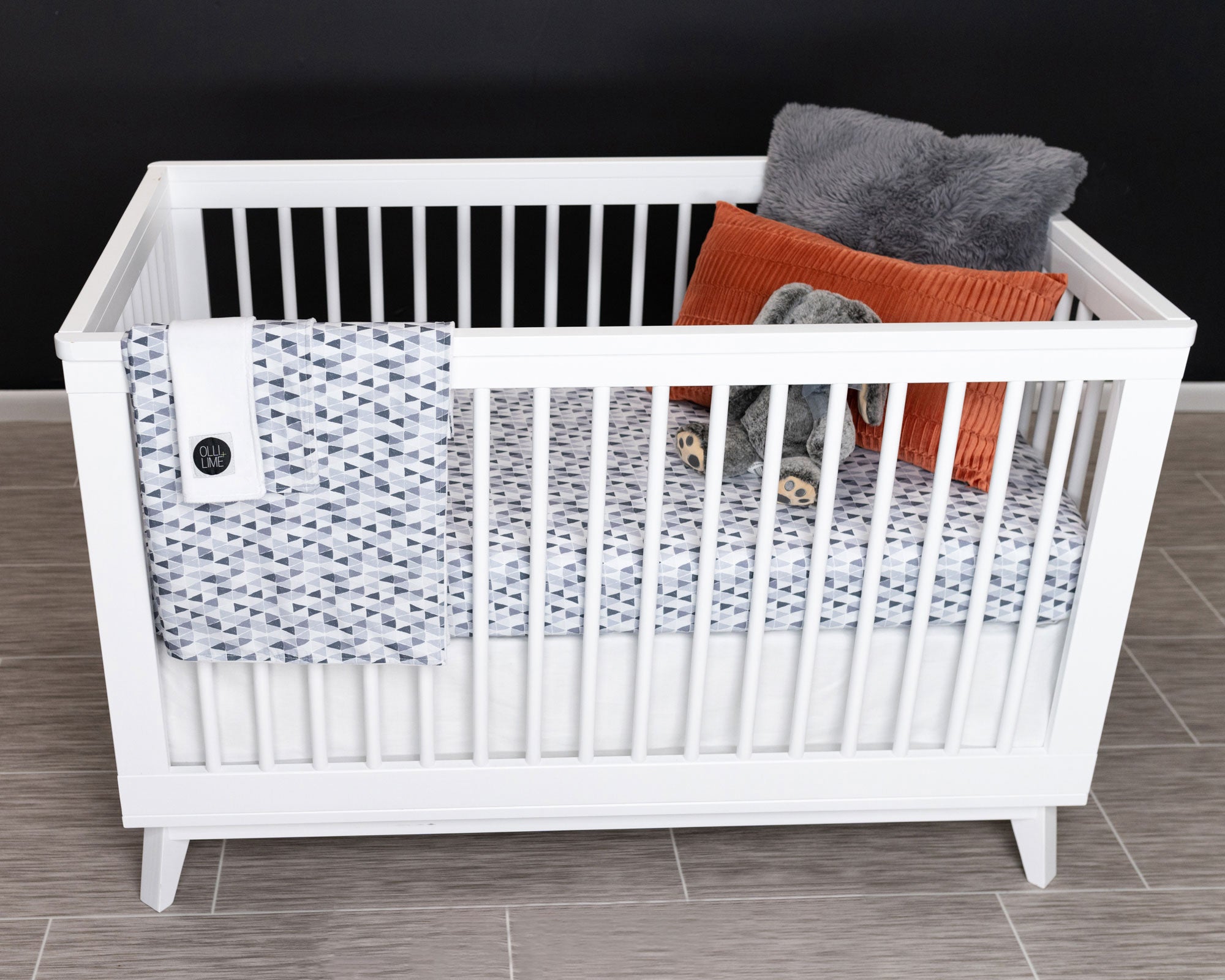 Gray Banners Marching Deluxe Crib Bedding Set featuring modern gray triangle patterns and soft cotton materials.