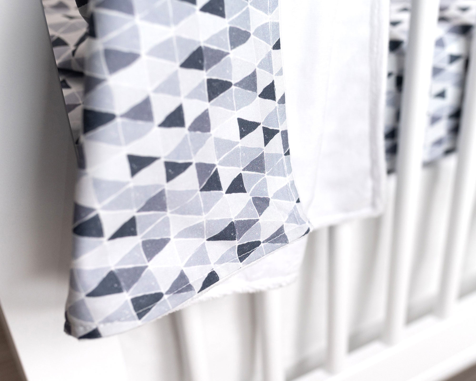 Gray Banners Marching Deluxe Crib Bedding Set featuring modern gray triangle patterns and soft cotton materials.