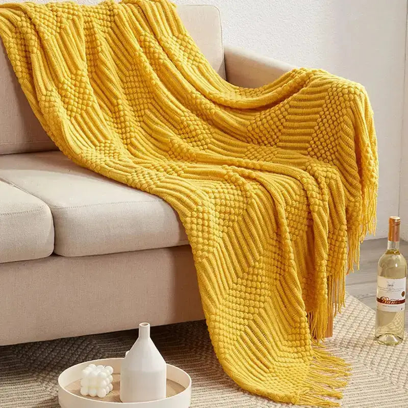 A cozy hand knitted tassel throw blanket in soft imitation cashmere, featuring intricate tassels and a stylish bohemian design.