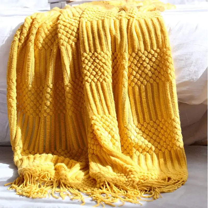 A cozy hand knitted tassel throw blanket in soft imitation cashmere, featuring intricate tassels and a stylish bohemian design.