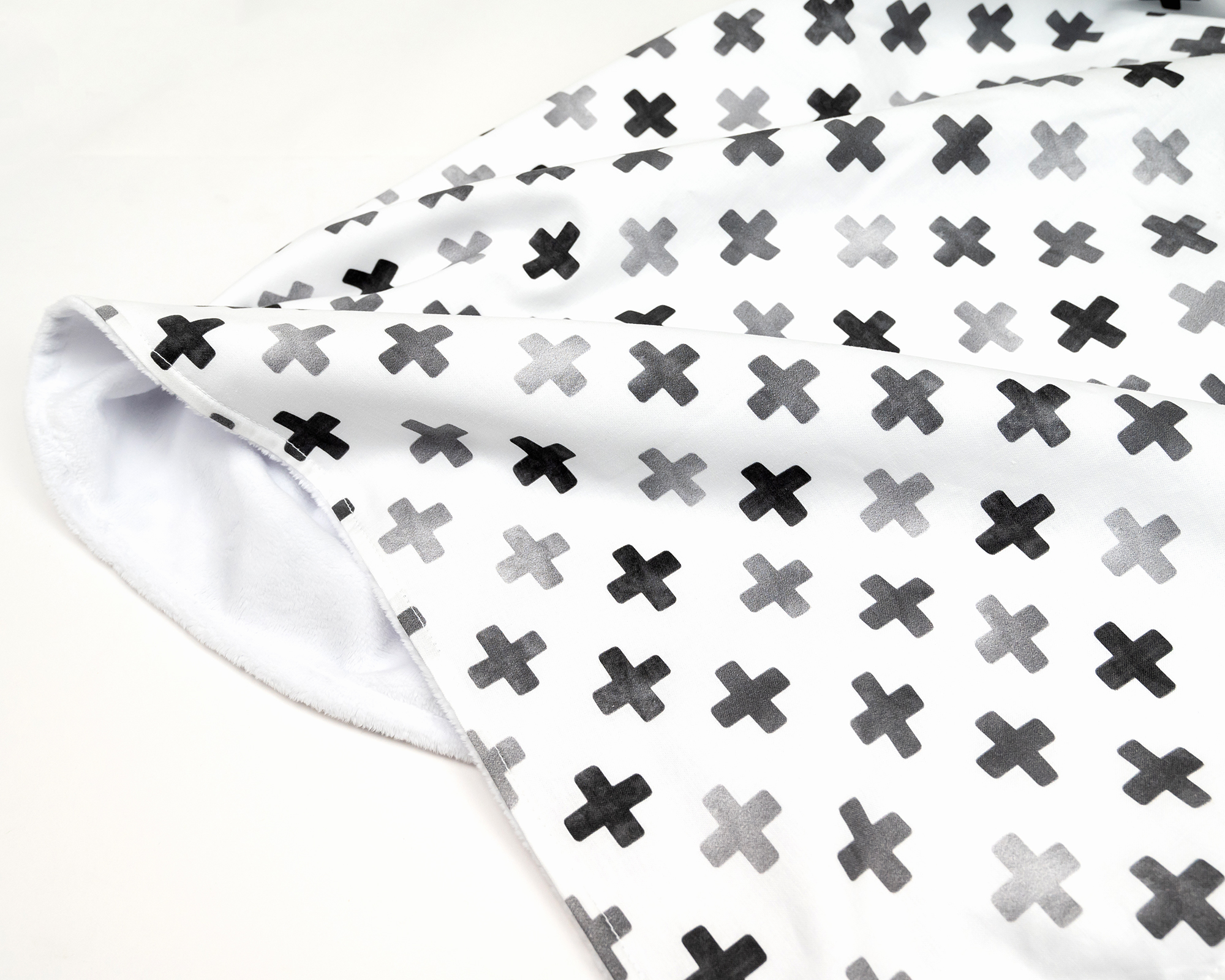 Hugo's Hazy Cross Baby Blanket featuring gray Swiss crosses on white, soft cotton fabric.