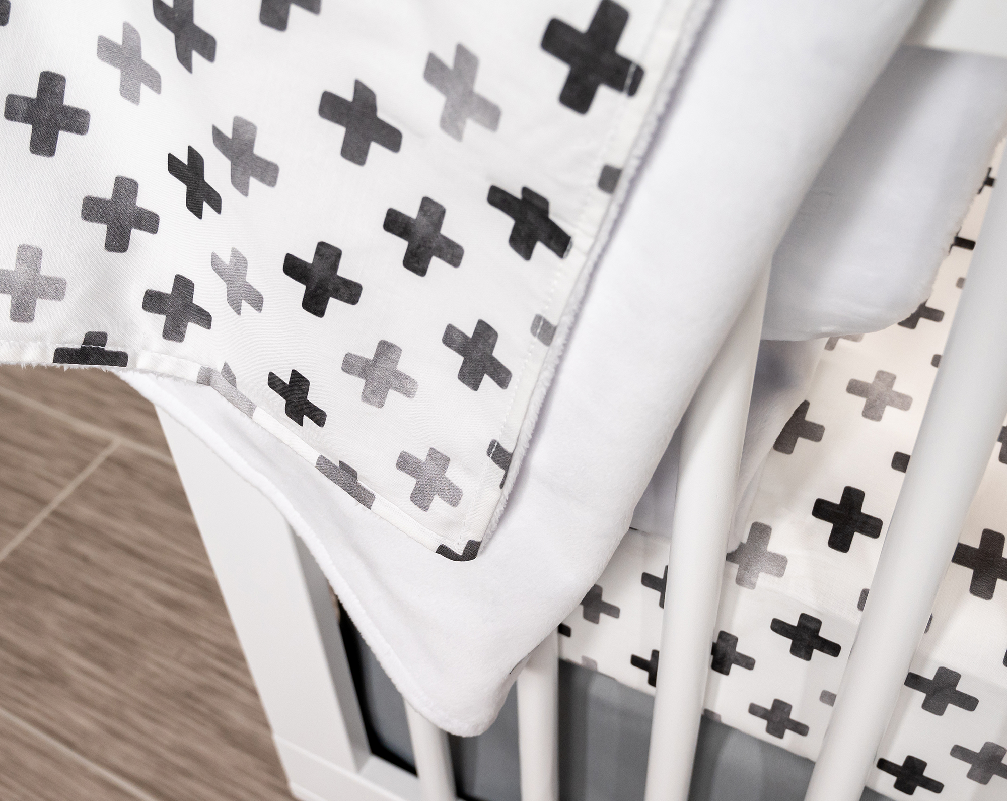 Hugo's Hazy Cross Baby Blanket featuring gray Swiss crosses on white, soft cotton fabric.