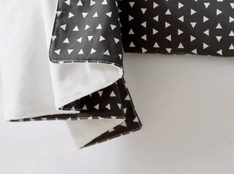 Kingsley Baby Blanket featuring modern triangle design in black and white, soft cotton front and minky back.