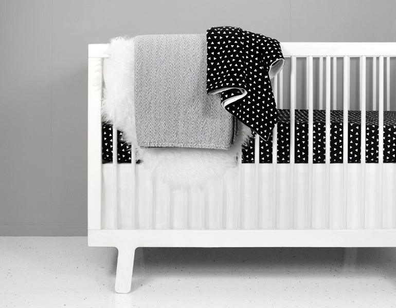 Kingsley Deluxe Crib Bedding Set featuring modern triangle designs in black and white with a grey weave blanket, perfect for stylish nurseries.