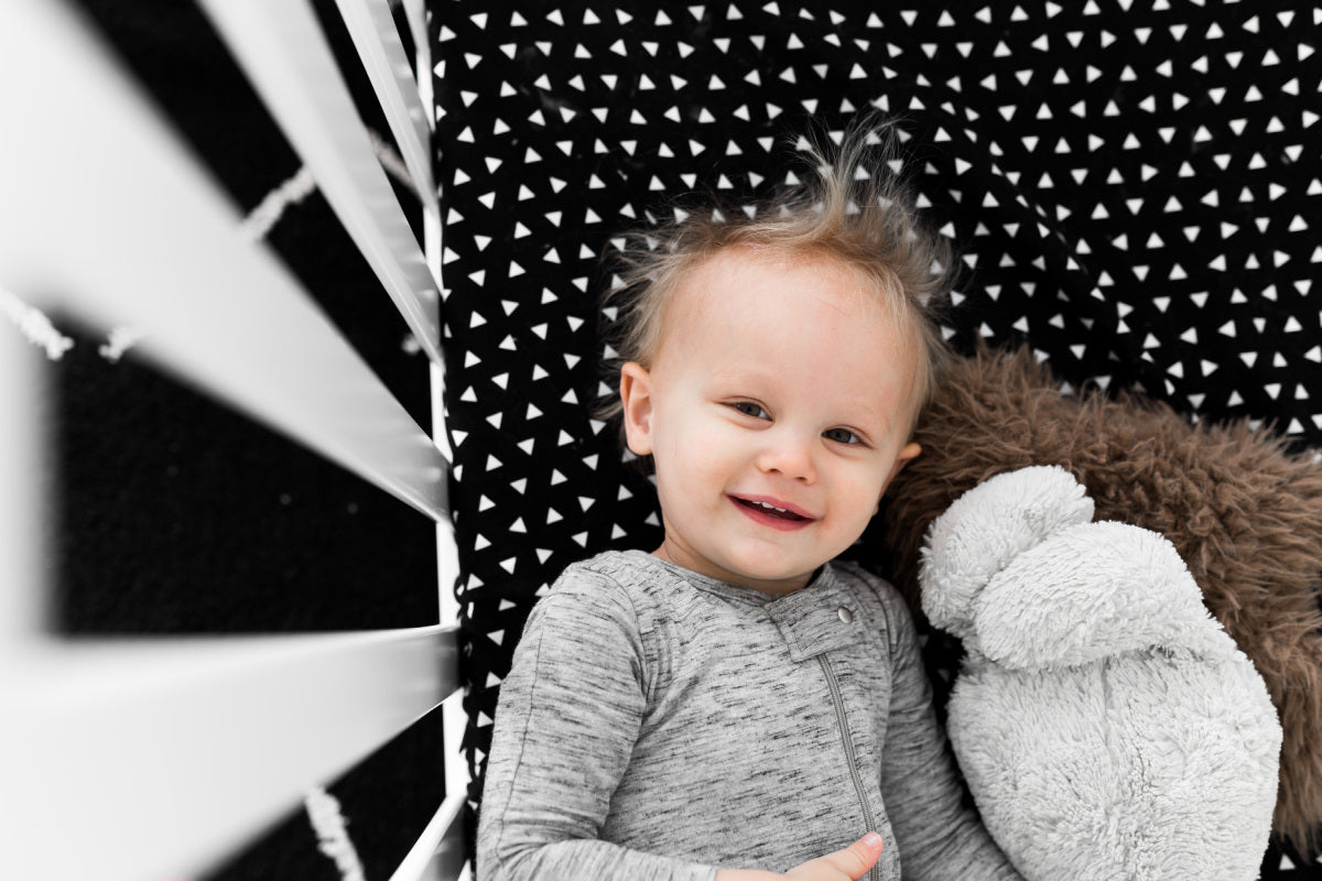 Kingsley Deluxe Crib Bedding Set featuring modern triangle designs in black and white with a grey weave blanket, perfect for stylish nurseries.