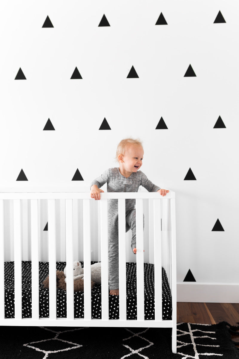 Kingsley Deluxe Crib Bedding Set featuring modern triangle designs in black and white with a grey weave blanket, perfect for stylish nurseries.