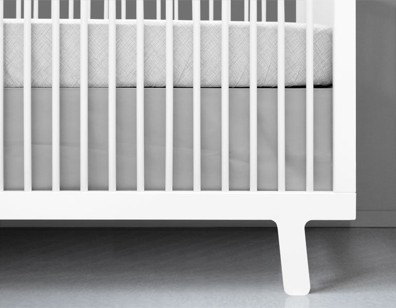 Light gray crib skirt with a crisp tailored design, made from heavyweight cotton twill, perfect for standard cribs.