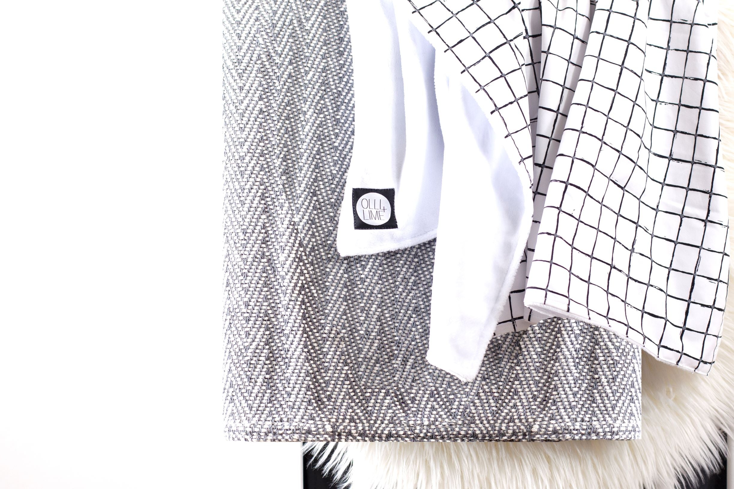 Luca Baby Blanket featuring a modern black grid pattern with soft white minky backing, perfect for stylish nurseries.