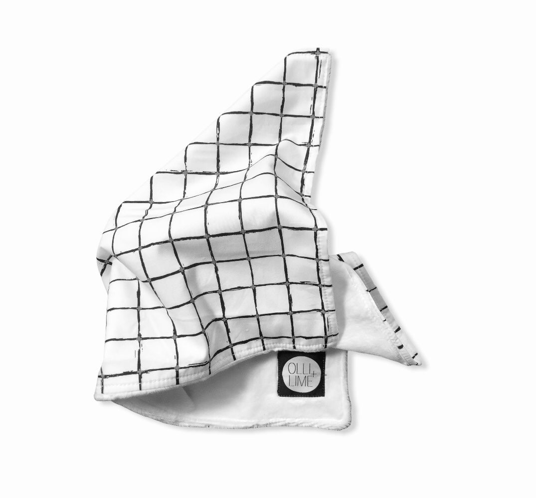 Luca Lovey security blanket featuring a modern black and white grid design, made from soft minky fabric and 100% cotton percale.