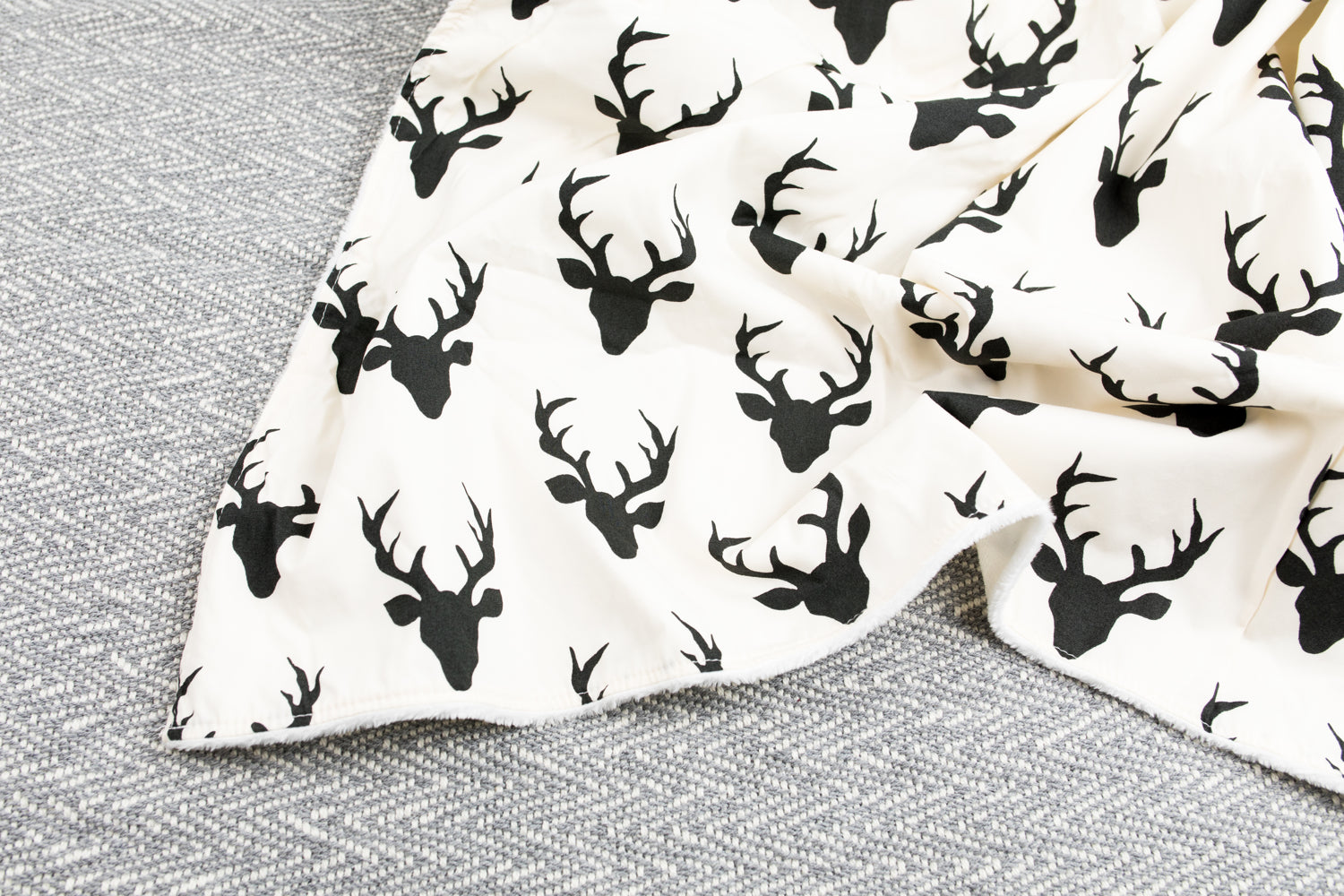 Mila Baby Blanket featuring a modern woodland deer design in off-white and black, with a soft minky backing, perfect for nurseries.