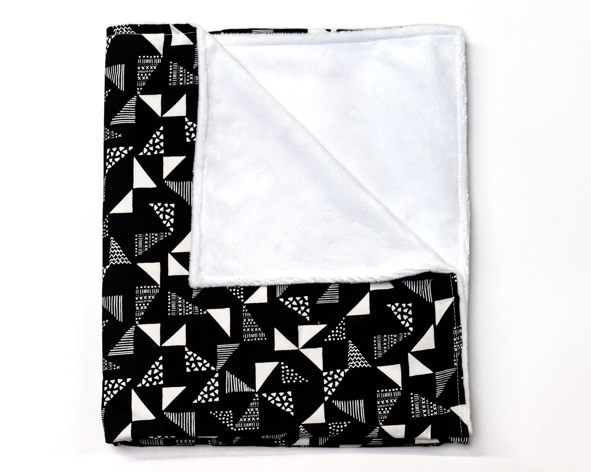 Pinwheels Crib Bedding Set featuring modern triangle patterns in gray and white on a black background, including a crib skirt, fitted sheet, and baby blanket.