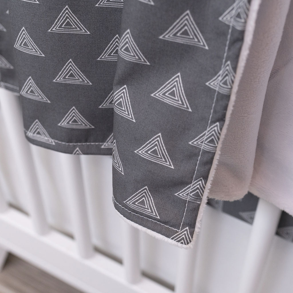 Tops for Tots Baby Blanket featuring light gray triangles on a dark gray background, made from 100% premium cotton with plush minky backing.