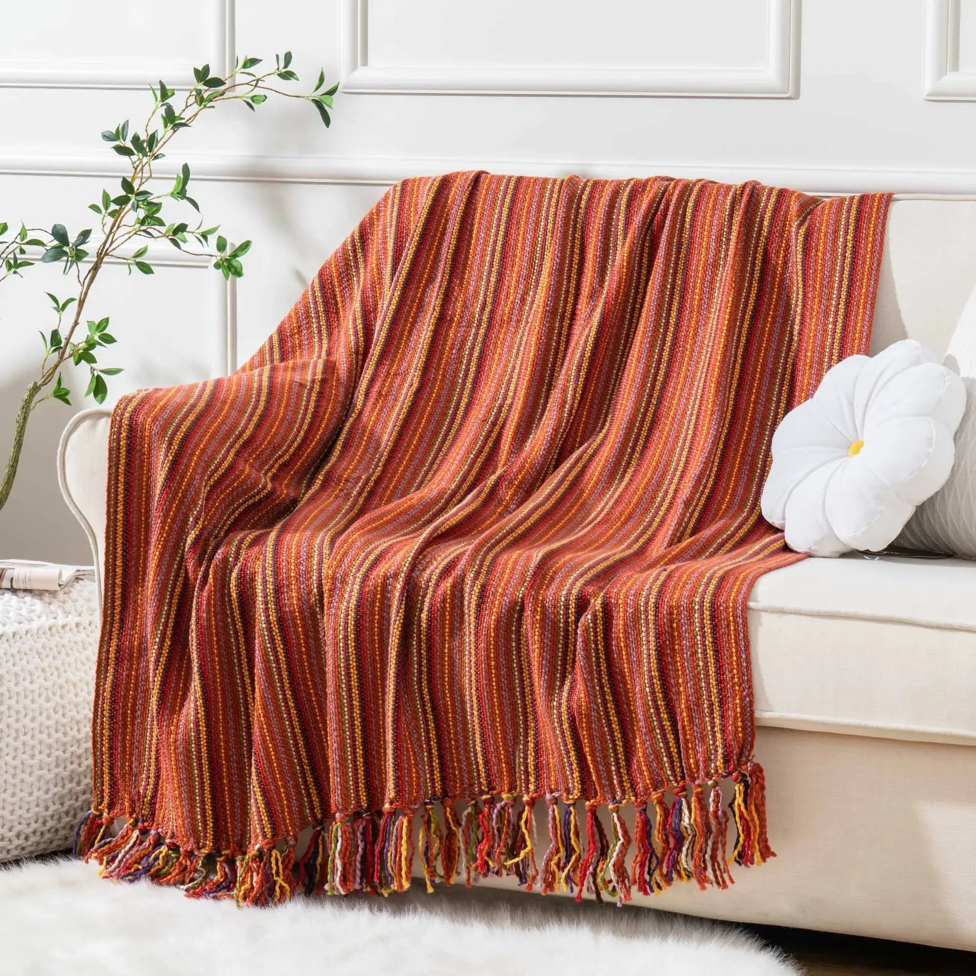 A cozy Varigated Tassel Throw featuring colorful patterns and tassels, perfect for home decor.