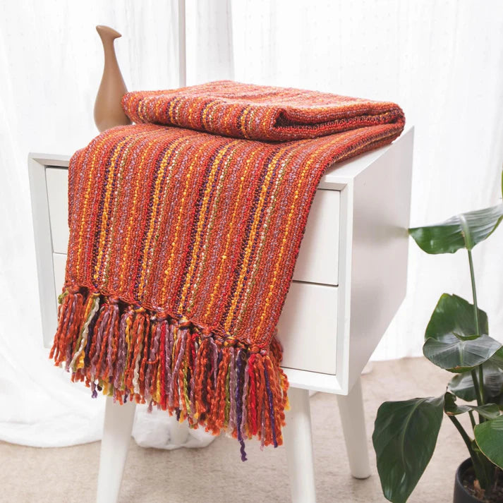 A cozy Varigated Tassel Throw featuring colorful patterns and tassels, perfect for home decor.