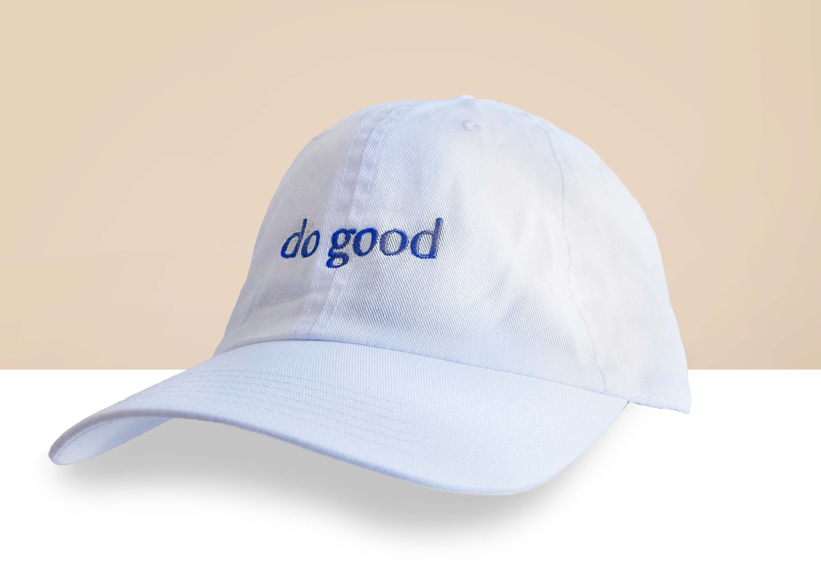 A stylish Blank Canvas White Baseball Hat featuring 'Do Good' embroidery, adjustable strap, and made from 100% cotton, perfect for casual wear.