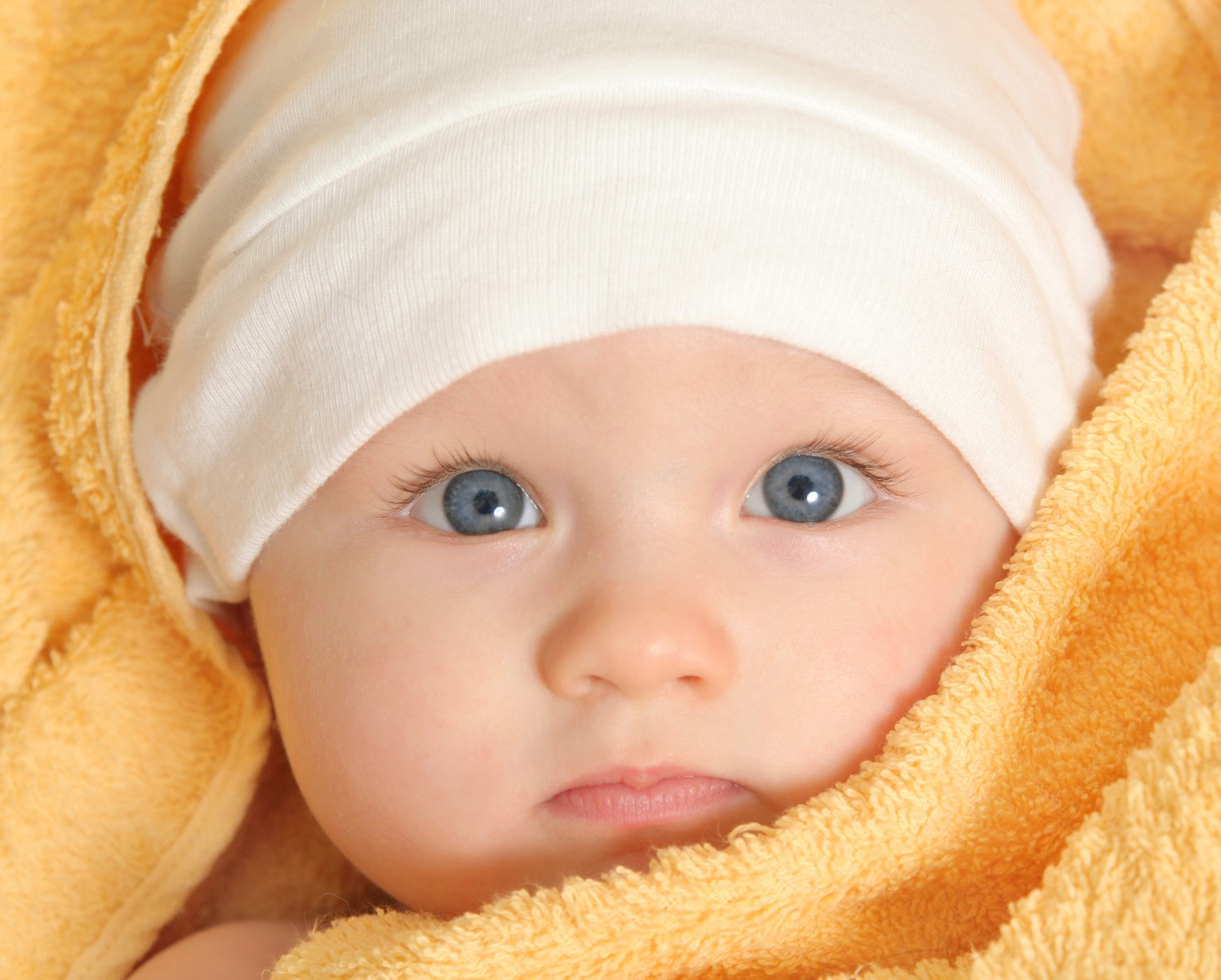 A pack of five blue and white baby caps made from soft cotton, designed for infants with a stretchy fit for comfort.