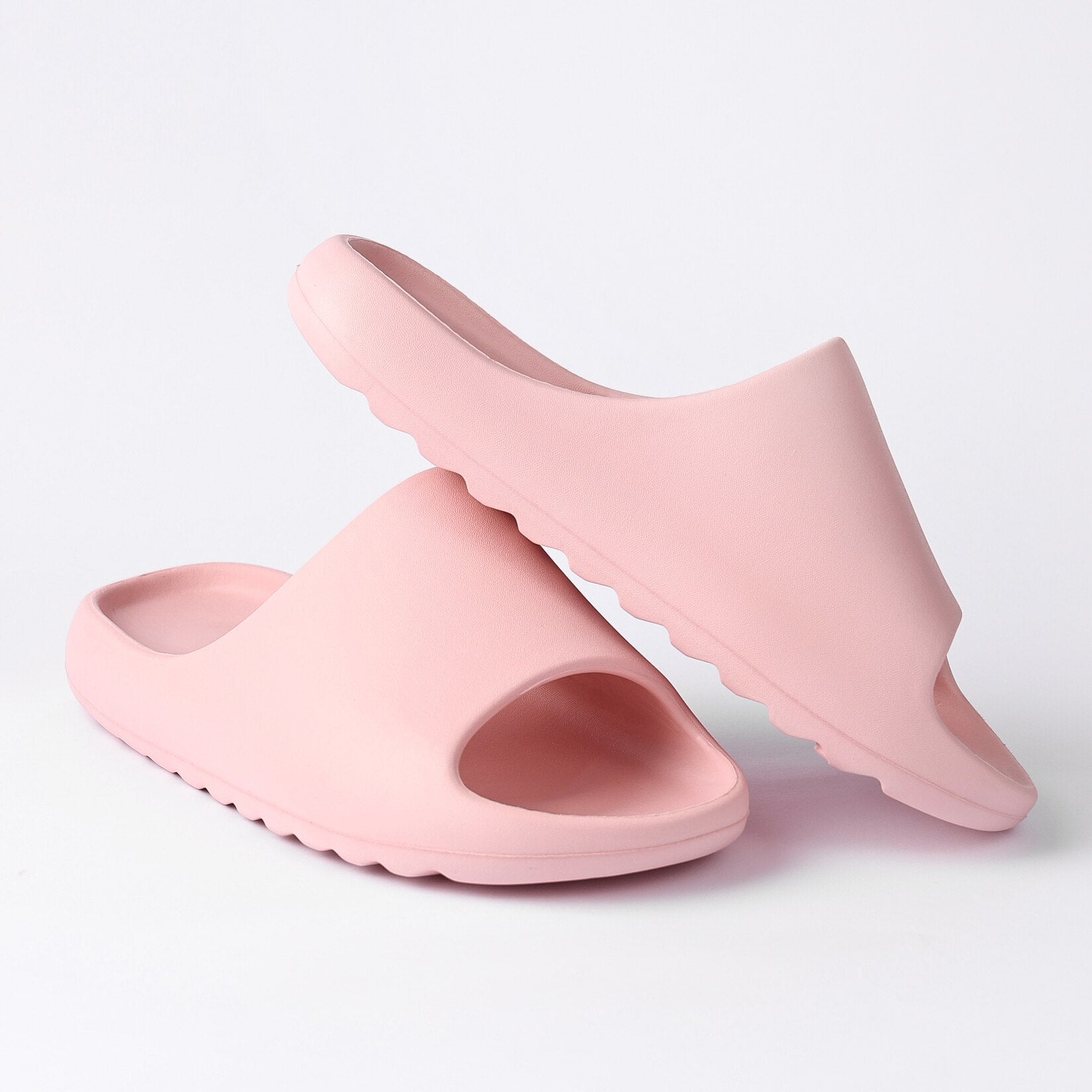 A pair of pink Cloud Pillow Slippers for women, featuring a soft EVA foam design, open toe, and a chunky platform base for comfort and style.