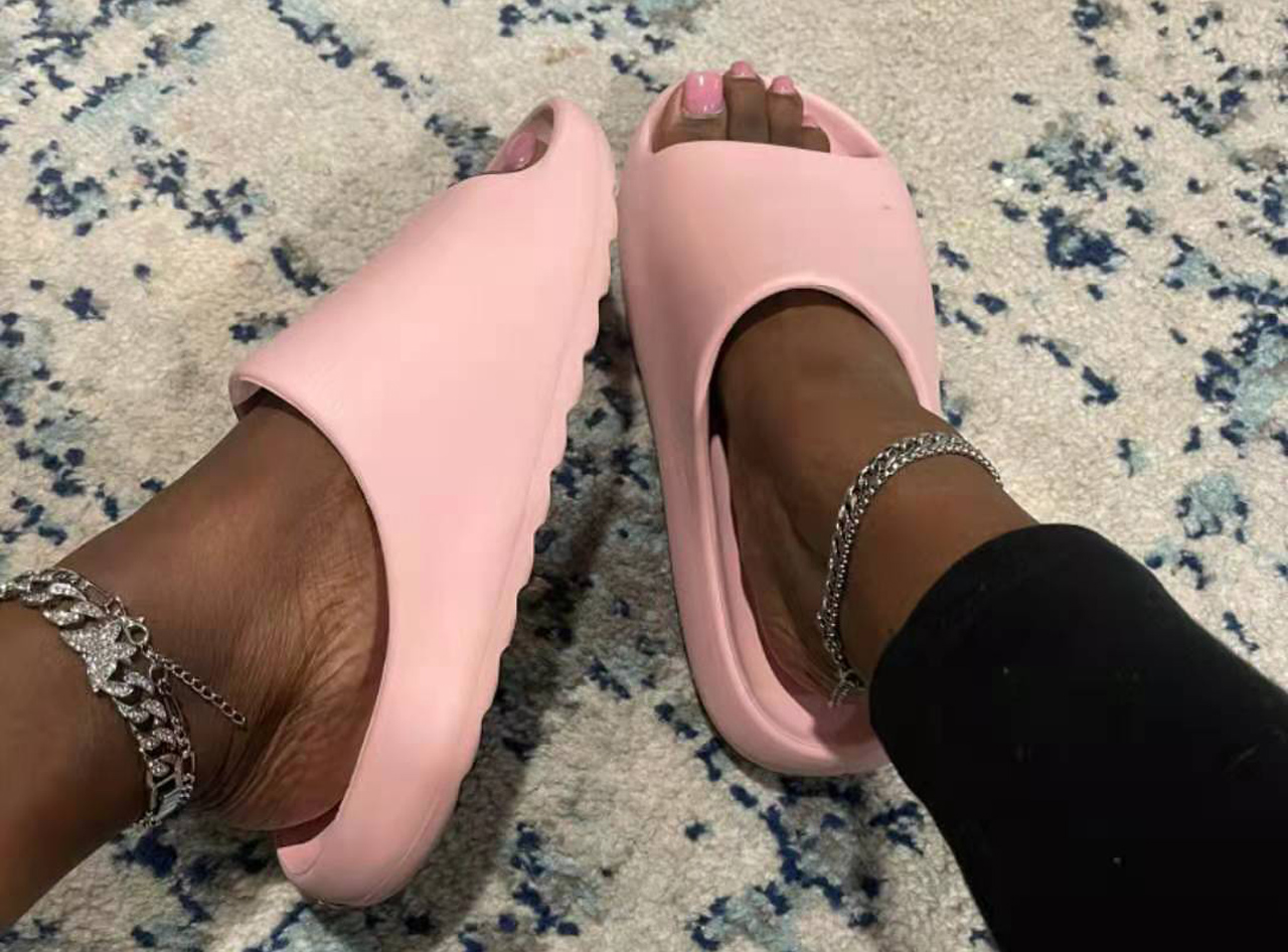 A pair of pink Cloud Pillow Slippers for women, featuring a soft EVA foam design, open toe, and a chunky platform base for comfort and style.