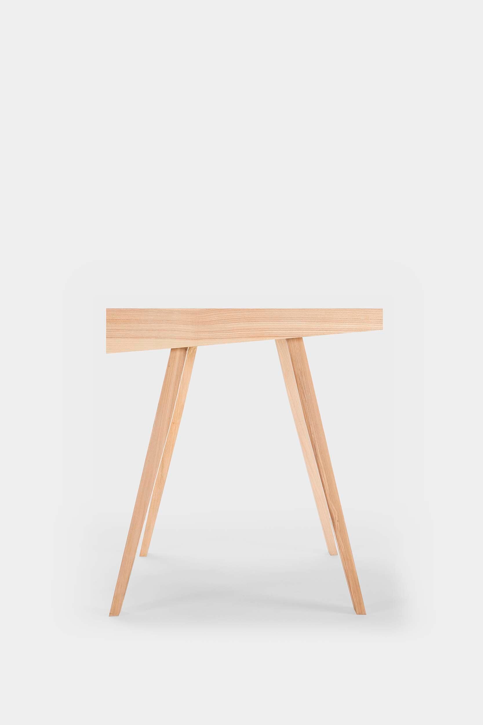 The 4.9 Desk by Marius Valaitis featuring a unique design with a storage slit and smooth surface, showcasing modern elegance and functionality.