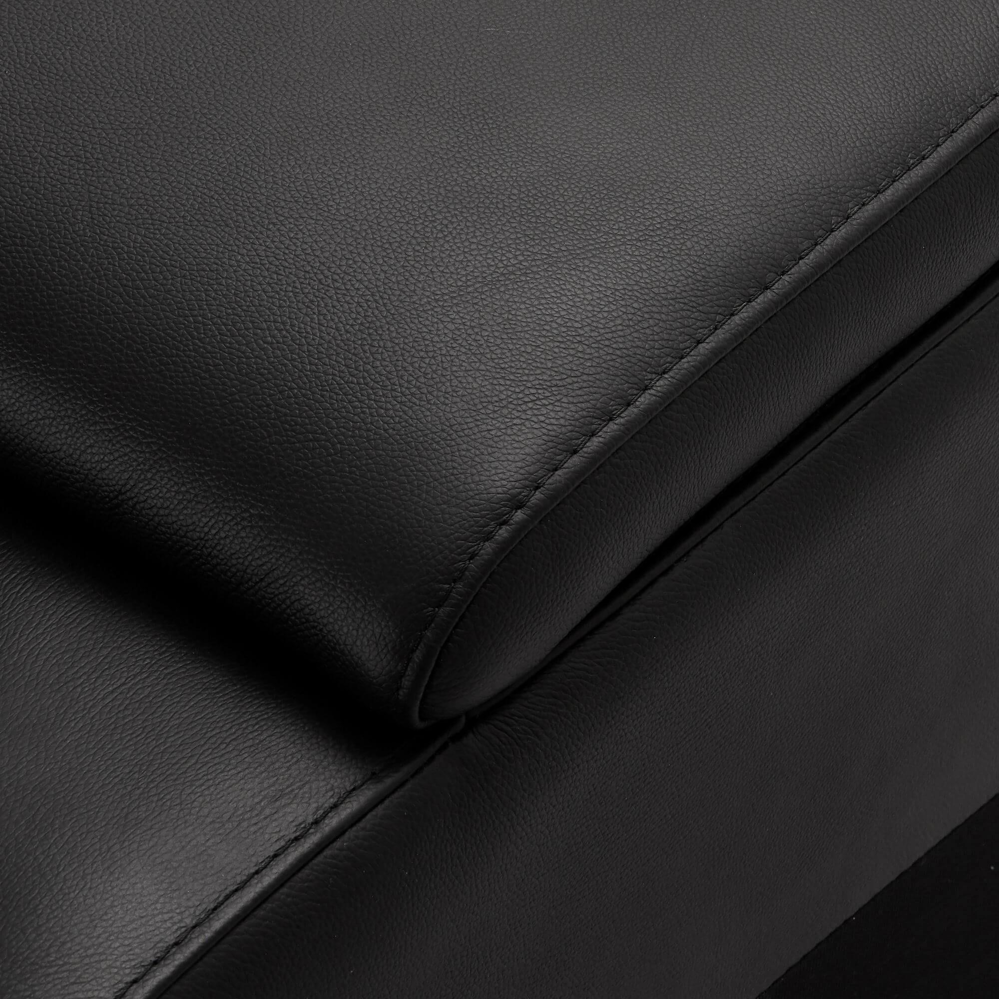 Elegant black leather bar sofa module with cupholders and wireless charger, featuring soft padded armrests.