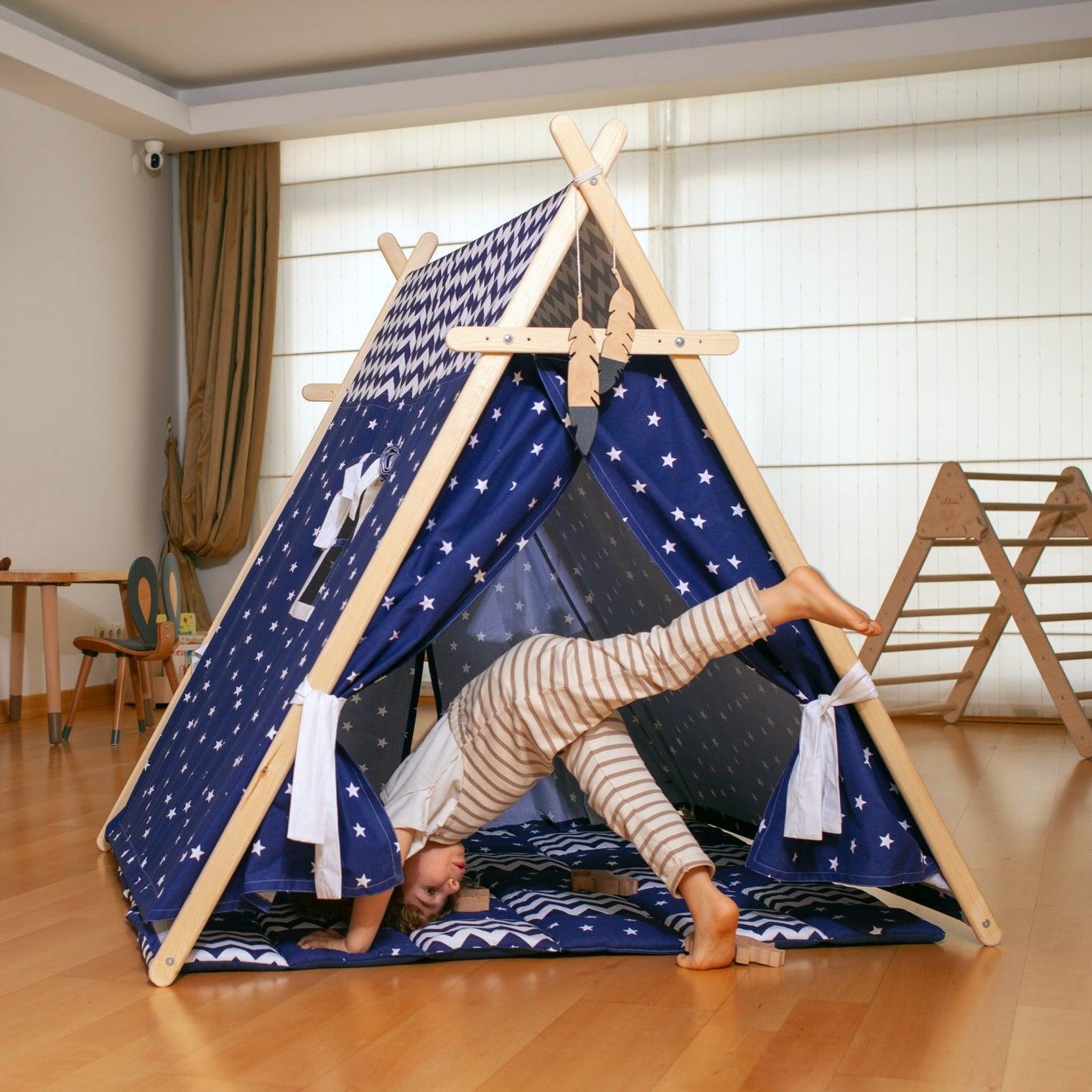 A colorful Blue Stars Play Tent and Play Mat set up in a cozy room, featuring star lights and wooden poles, perfect for children's imaginative play.