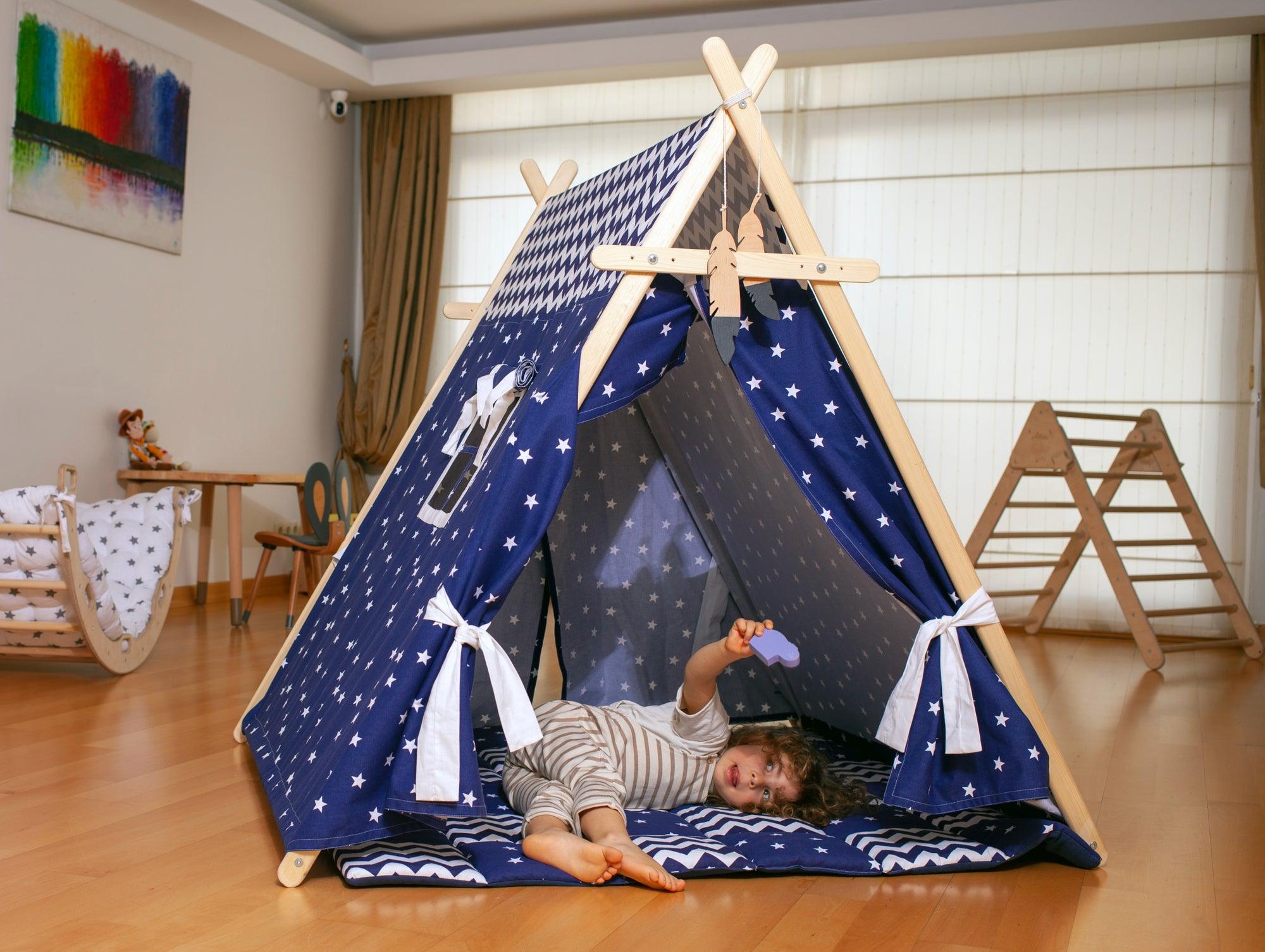 A colorful Blue Stars Play Tent and Play Mat set up in a cozy room, featuring star lights and wooden poles, perfect for children's imaginative play.