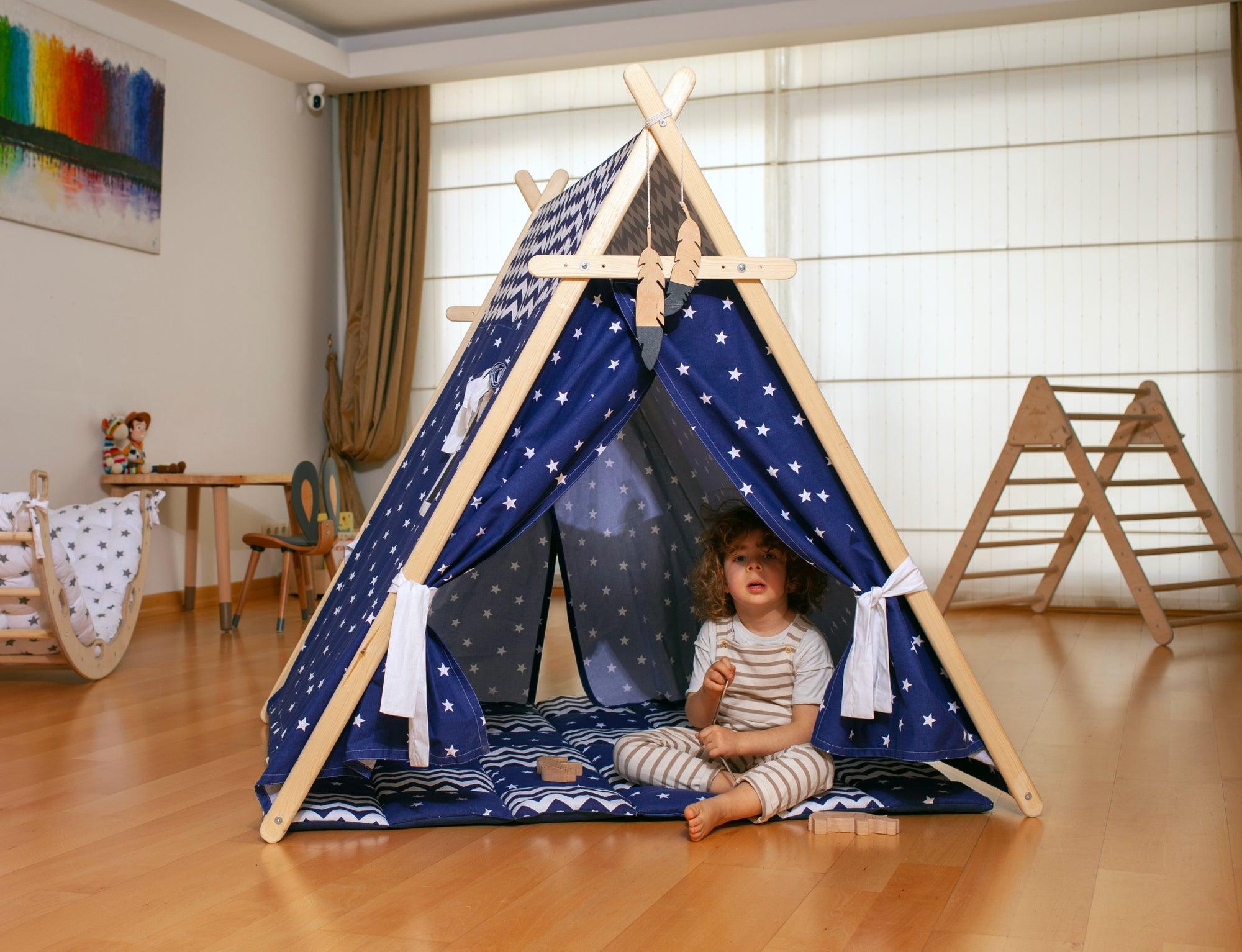 A colorful Blue Stars Play Tent and Play Mat set up in a cozy room, featuring star lights and wooden poles, perfect for children's imaginative play.