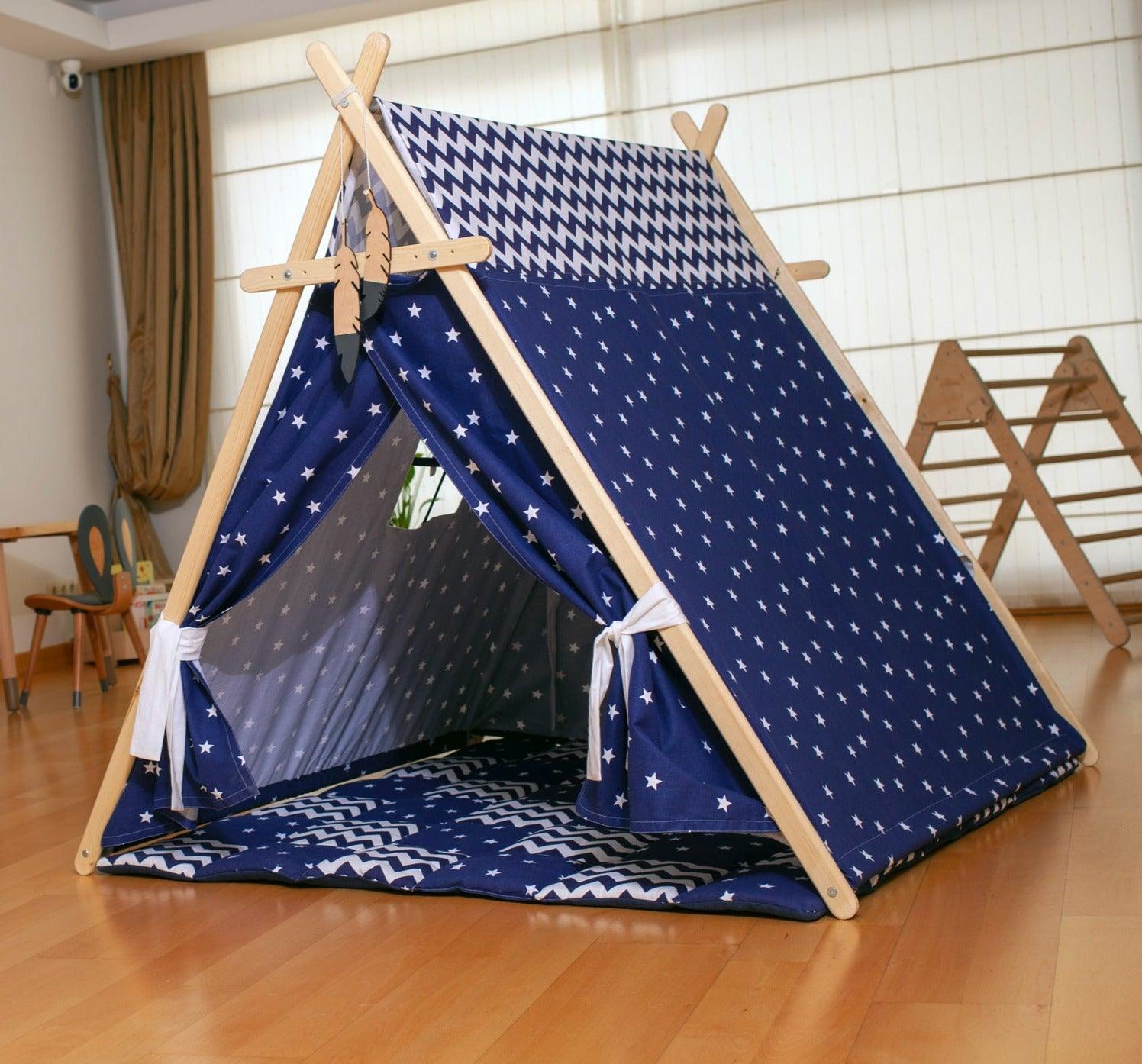 A colorful Blue Stars Play Tent and Play Mat set up in a cozy room, featuring star lights and wooden poles, perfect for children's imaginative play.