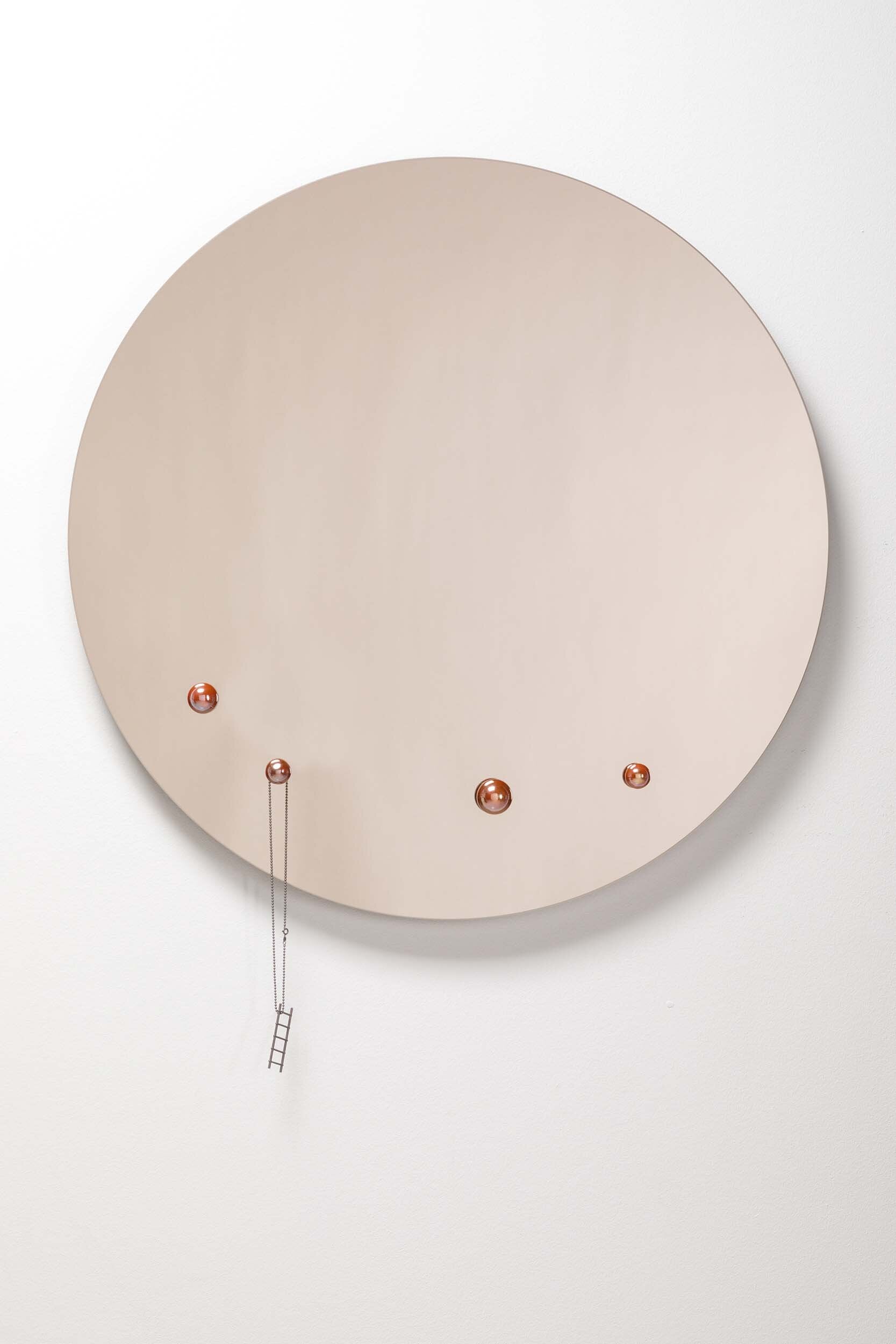 The Dew Mirror designed by Rasa Balaišė, featuring a reflective surface and four decorative glass droplets, available in bronze, dark grey, and clear finishes.