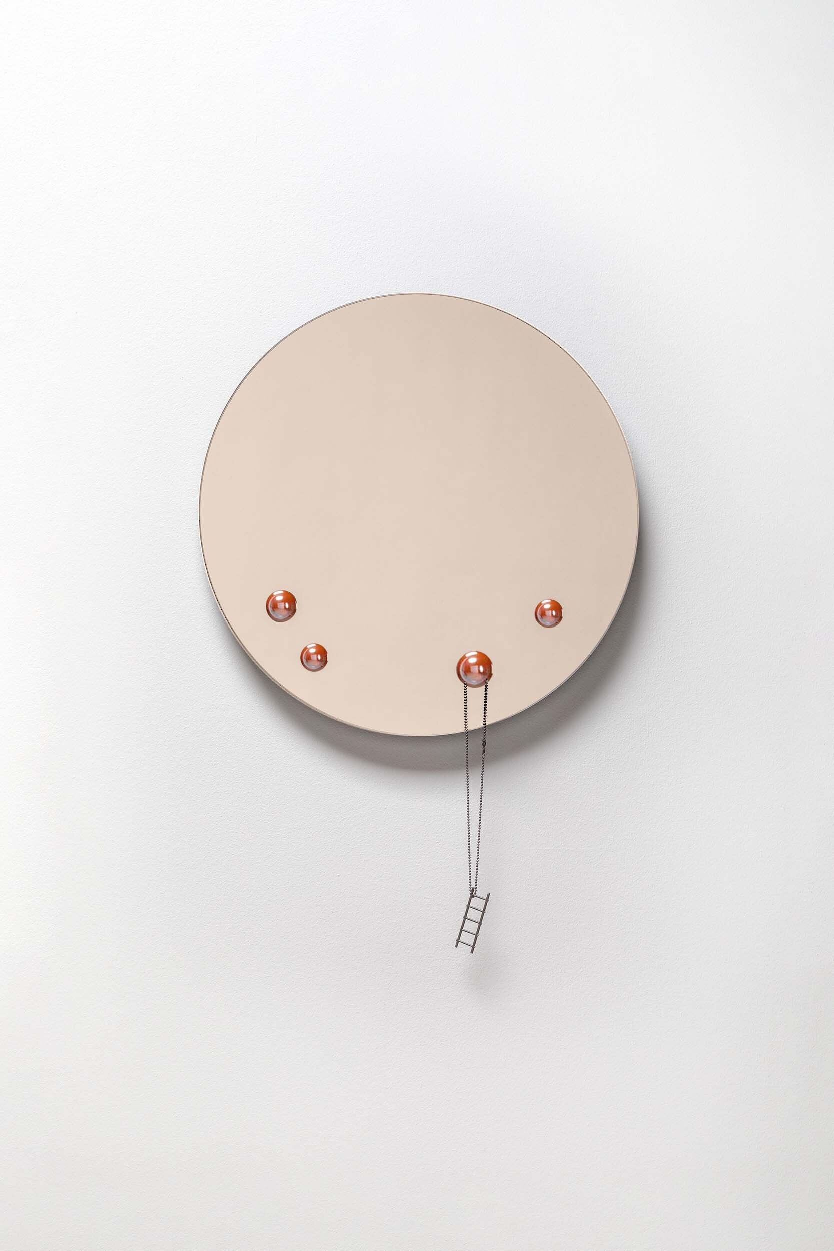 The Dew Mirror designed by Rasa Balaišė, featuring a reflective surface and four decorative glass droplets, available in bronze, dark grey, and clear finishes.