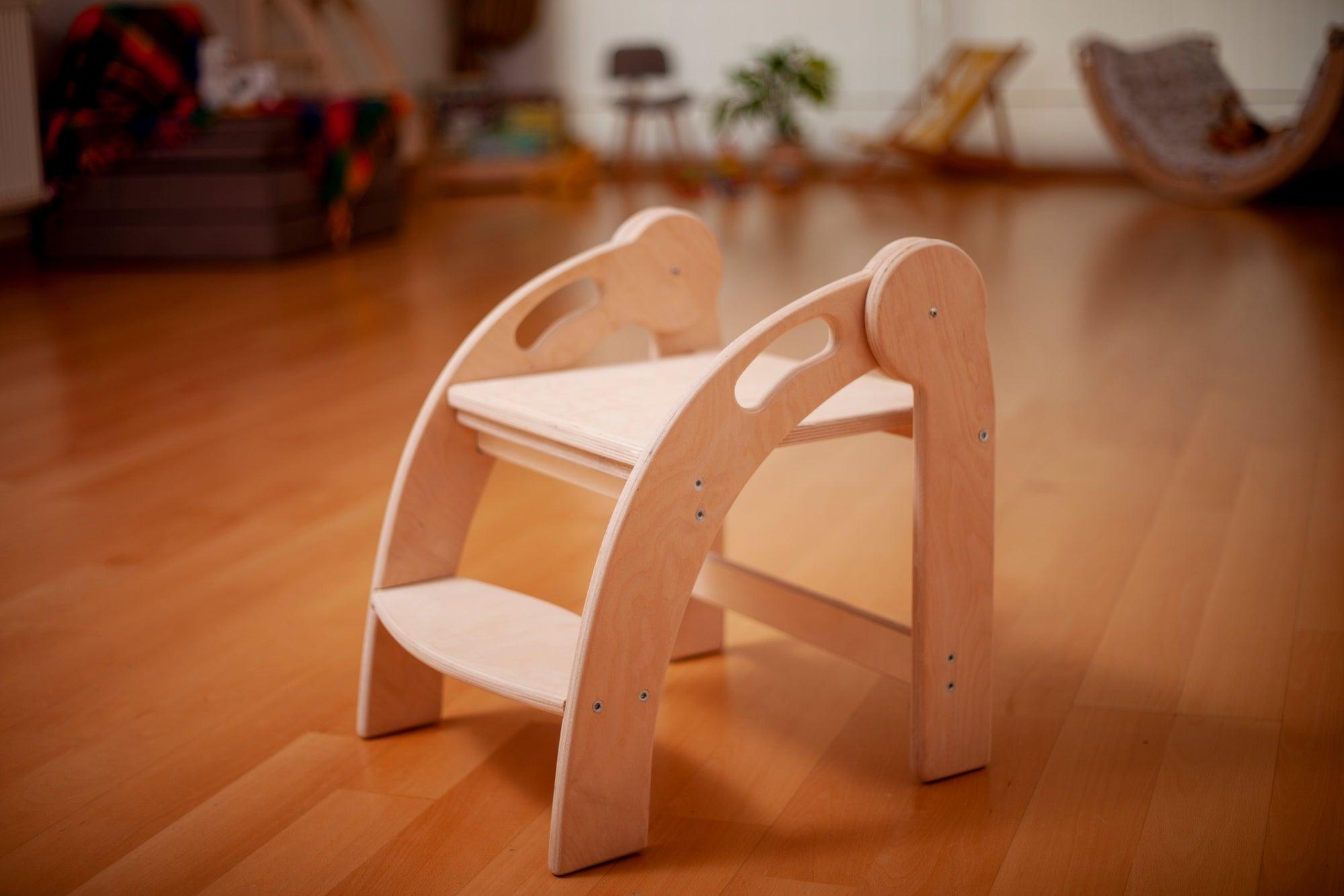 Foldable Montessori Kitchen Step Stool made of natural birch plywood, featuring two steps for children to reach higher surfaces safely.