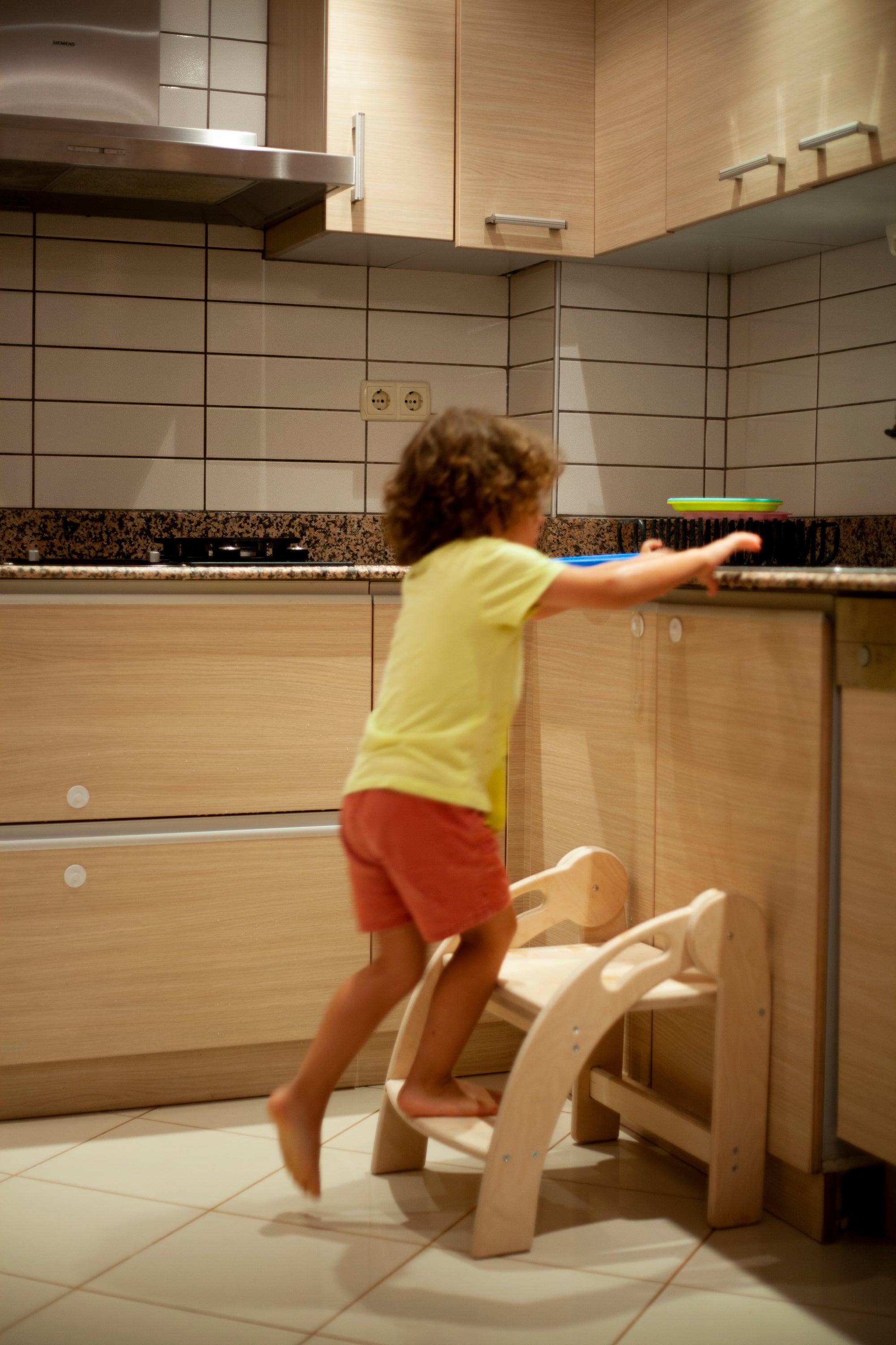 Foldable Montessori Kitchen Step Stool made of natural birch plywood, featuring two steps for children to reach higher surfaces safely.