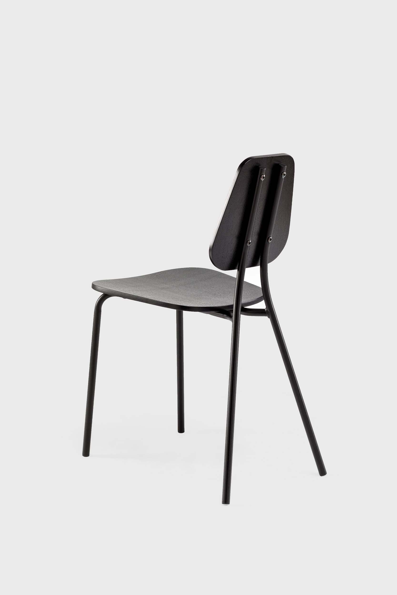 The Hoya Chair features a sleek black metal frame with a veneered plywood seat and backrest, available in natural oil, black, and walnut finishes, showcasing its modern design.