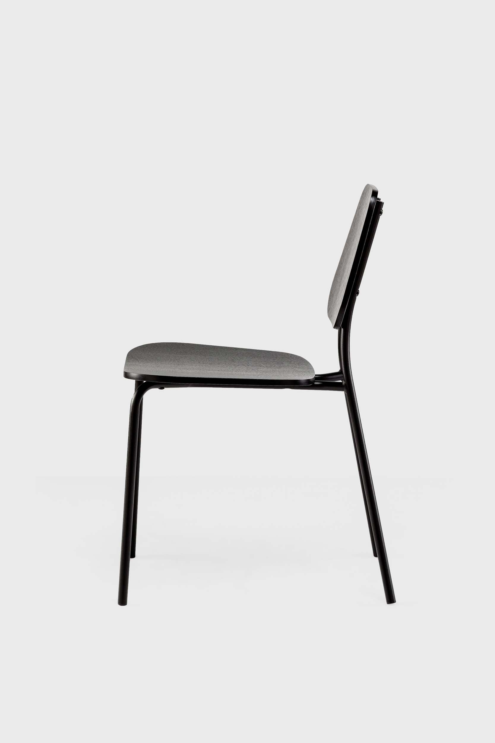 The Hoya Chair features a sleek black metal frame with a veneered plywood seat and backrest, available in natural oil, black, and walnut finishes, showcasing its modern design.