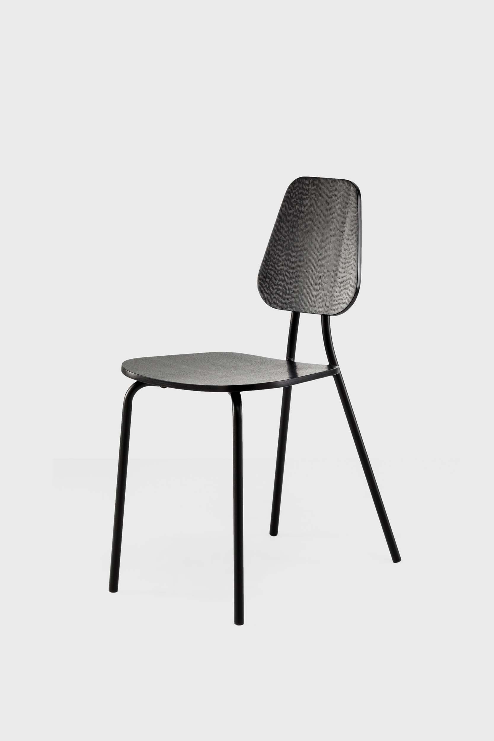 The Hoya Chair features a sleek black metal frame with a veneered plywood seat and backrest, available in natural oil, black, and walnut finishes, showcasing its modern design.