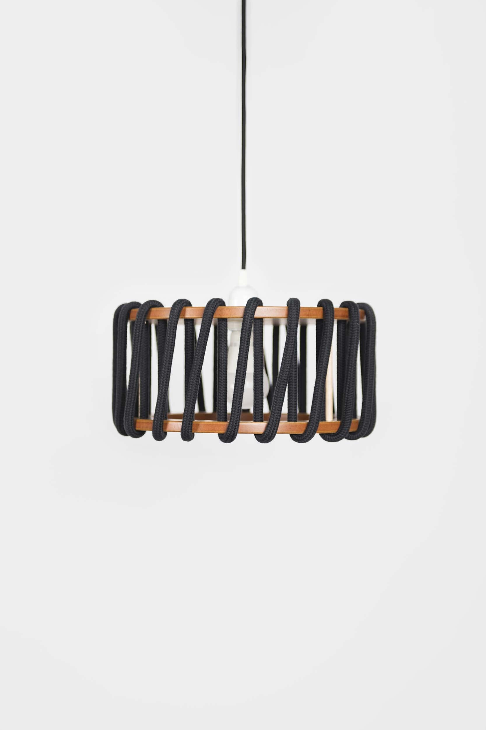 Stylish Macaron Pendant Lamp designed by Silvia Ceñal, featuring wooden elements and a textured cord, perfect for modern interiors.