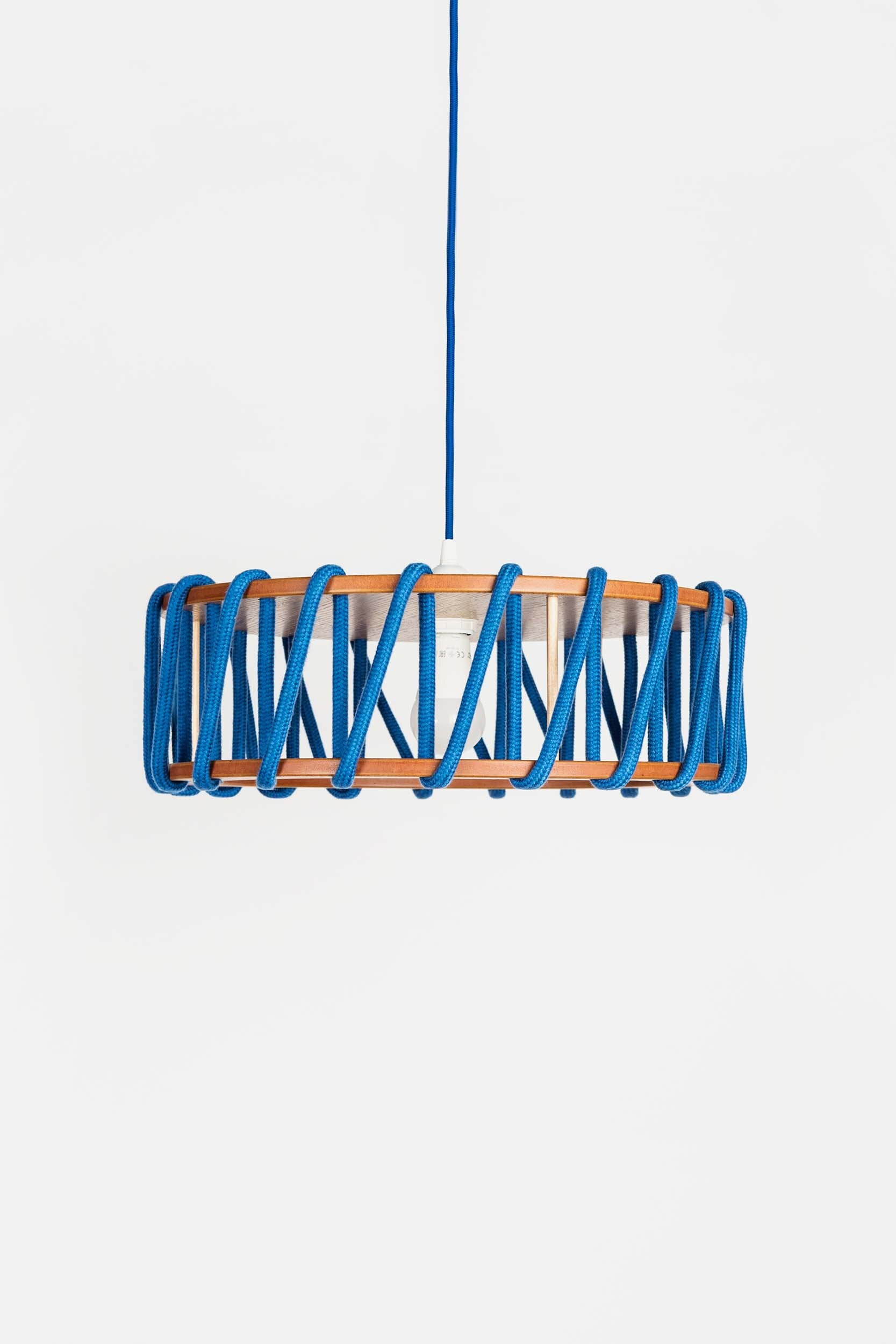 Stylish Macaron Pendant Lamp designed by Silvia Ceñal, featuring wooden elements and a textured cord, perfect for modern interiors.