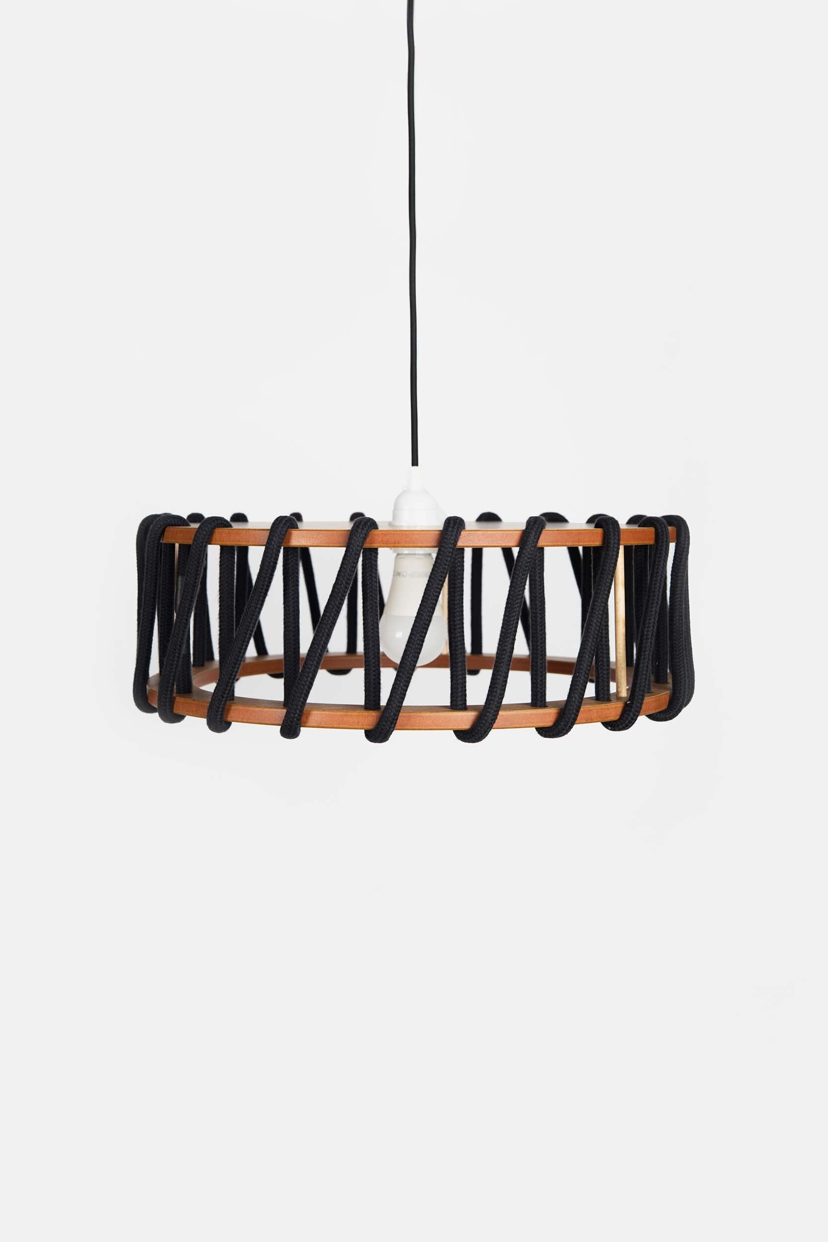 Stylish Macaron Pendant Lamp designed by Silvia Ceñal, featuring wooden elements and a textured cord, perfect for modern interiors.